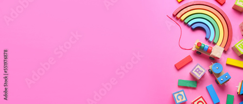 Set of children's toys on pink background with space for text