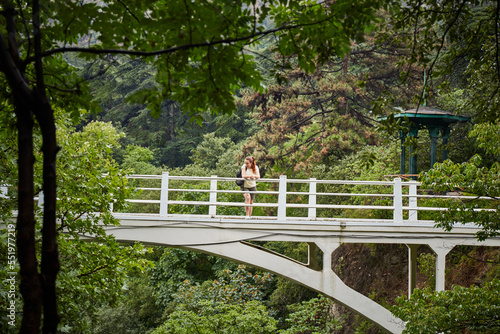 Female tourist in Tbilisi botanical garden. Rainy day in Tbilisi botanical garden. Tbilisi, Georgia