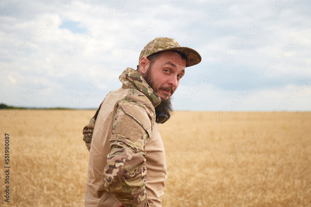 Ukrainian military man in wheat field. Ukrainian wheat fields and war upcoming food crisis. Armed Forces of Ukraine Ukrainian military man in wheat field. Ukrainian wheat fields and war upcoming food crisis. Armed Forces of Ukraine
