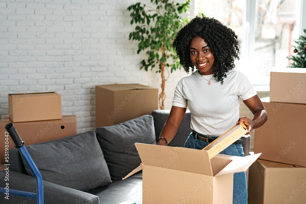 Happy african young woman with cardboard box moving to a new place Happy african young woman with cardboard box moving to a new place