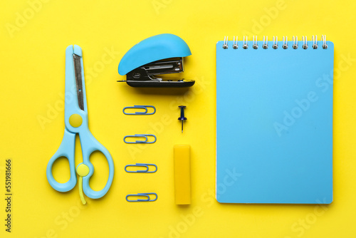 Set of stationery with stapler on yellow background photo