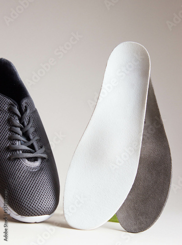 Gray sport shoes  with orthopedic insoles. Foot care products conception.