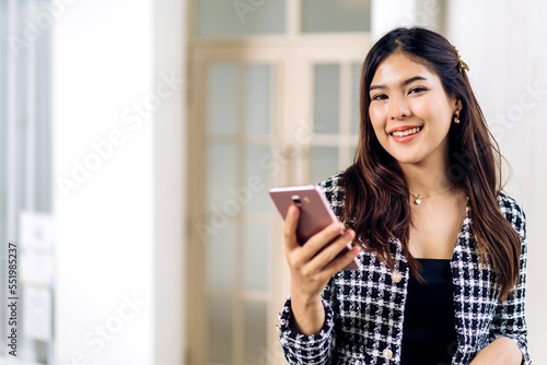 Portrait of smiling happy beautiful asian woman relaxing using digital smartphone.Young asian girl looking at screen typing message and playing game online or social media at cafe