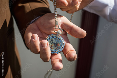 Un homme tiens dans sa main une montre à gousset photo