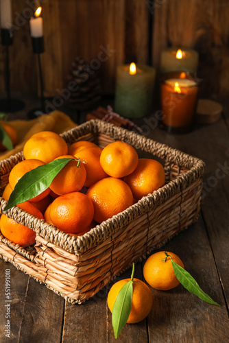 Basket with ripe tangerines on wooden table