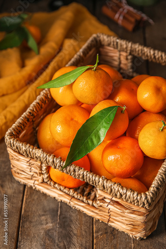 Fototapeta Naklejka Na Ścianę i Meble -  Basket with ripe tangerines on wooden table, closeup