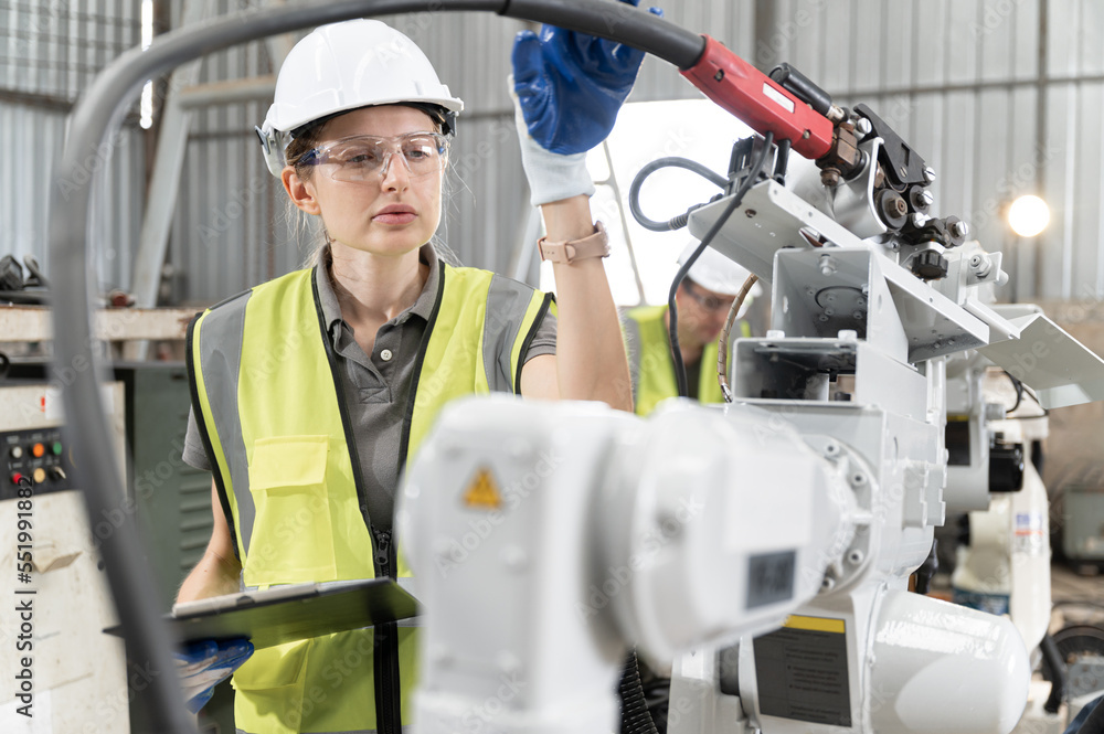 Caucasian technician engineer woman use tablet computer control with checking machine arm robot at factory Caucasian technician engineer woman use tablet computer control with checking machine arm robot at factory