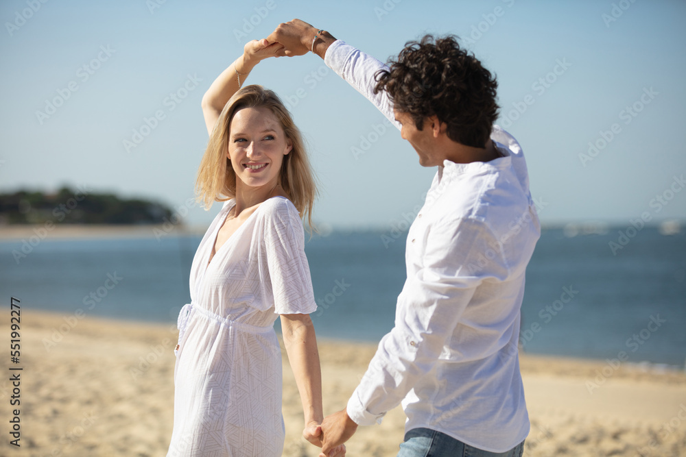 young couple enjoying each other on a beach young couple enjoying each other on a beach