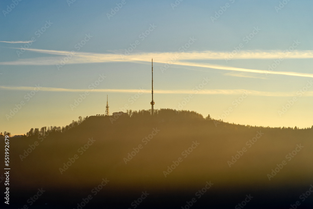 Obraz premium Aerial view over city of Zürich with local mountain Uetliberg in the background and bright sunlight and beautiful autumn evening sun. Photo taken December 6th, 2022, Zurich, Switzerland.