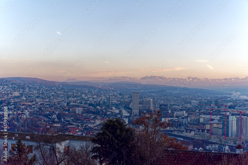 Aerial view over City of Zürich with Limmat River and Swiss Alps in the background on a sunny autumn evening. Photo taken December 6th, 2022, Zurich, Switzerland.