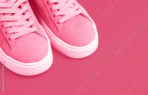 Female sneakers fashion trend color 2023 Viva Magenta close-up, copy space.