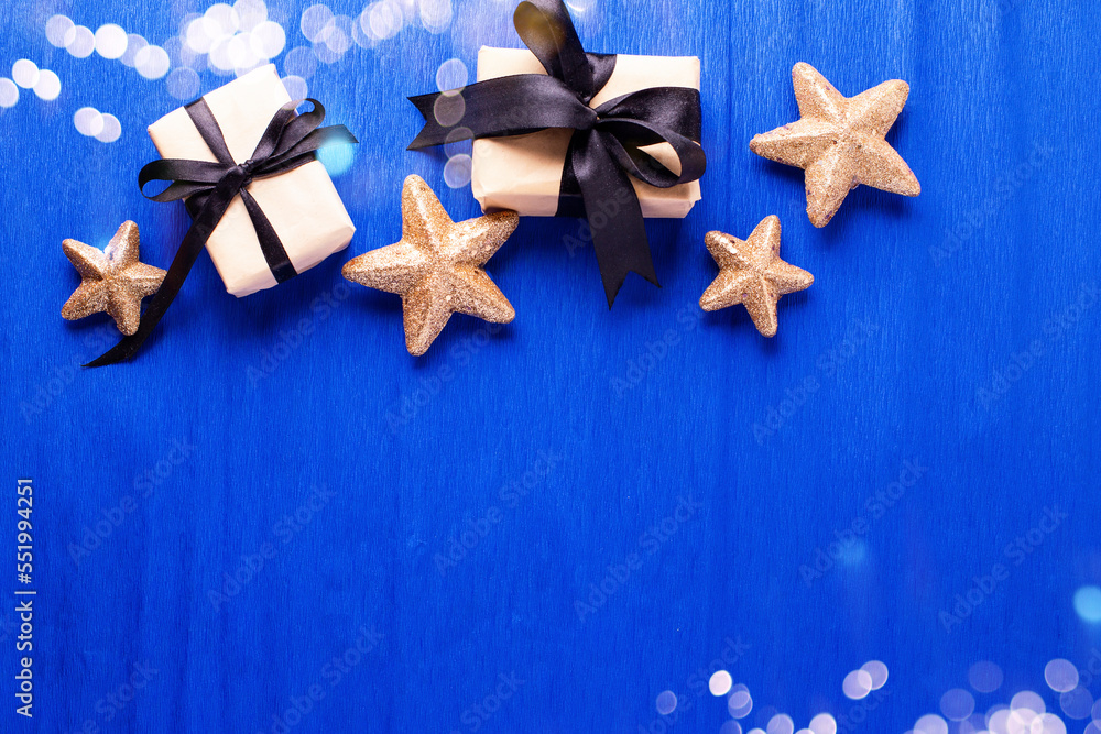 Frame from wrapped boxes with presents and golden decorative stars on blue paper textured background. Place for text. Flat lay. Holiday layout. Frame from wrapped boxes with presents and golden decorative stars on blue paper textured background. Place for text. Flat lay. Holiday layout.