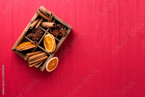 Vintage box with spices - cinnamone, slices of dried orange, anise on textured paper background. Top view. Place for text. photo