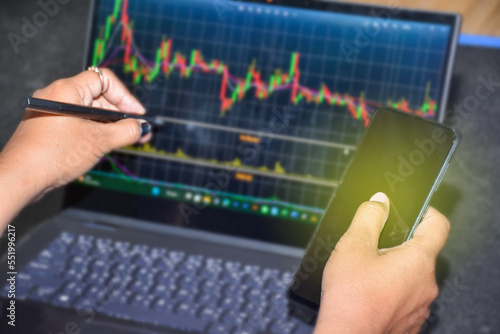 Businessman hand holding smartphone checking stock market data online