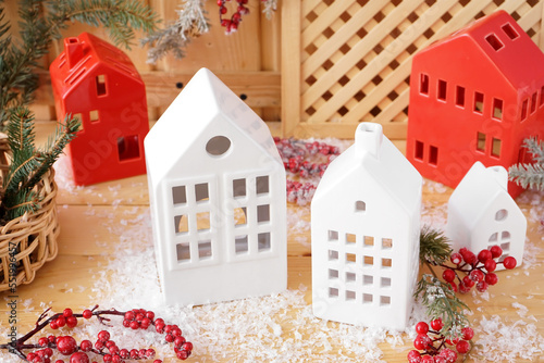 Stylish candle holders, Christmas decor and snow on wooden table