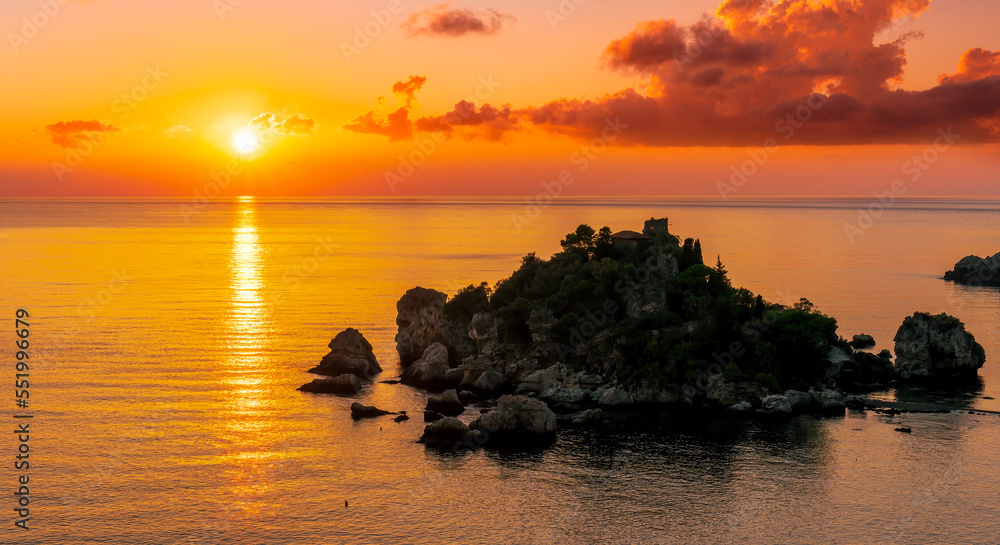 amazing view to a sunrise or sunset above beautiful isle in sea with nice coasline and clouds on the background of the evening sea landscape