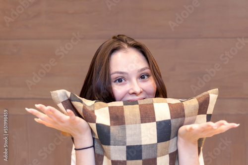 Portrait of aastonished , pleasantly surprised girl with beautiful eyes hugging a pillow. photo