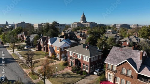 Upscale homes in Oklahoma City. Capitol building in distance. Rising aerial reveal shot. photo