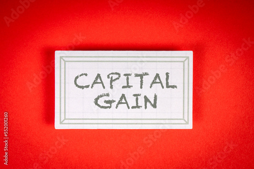 CAPITAL GAIN. Sticky note with text on a red background