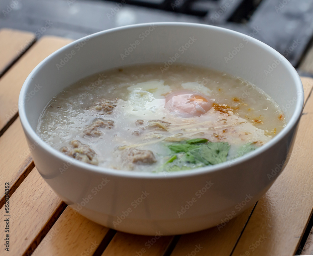 Pork boiled rice with egg in white bowl on wooden table Pork boiled rice with egg in white bowl on wooden table