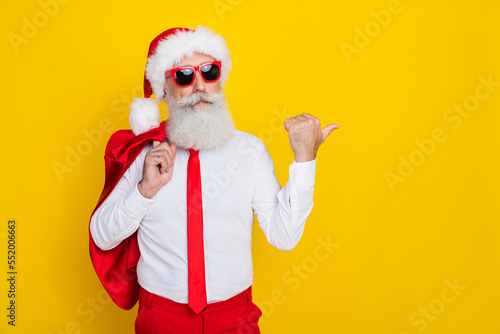 Photo of elegant person indicate thumb finger empty space x-mas proposition isolated on yellow color background