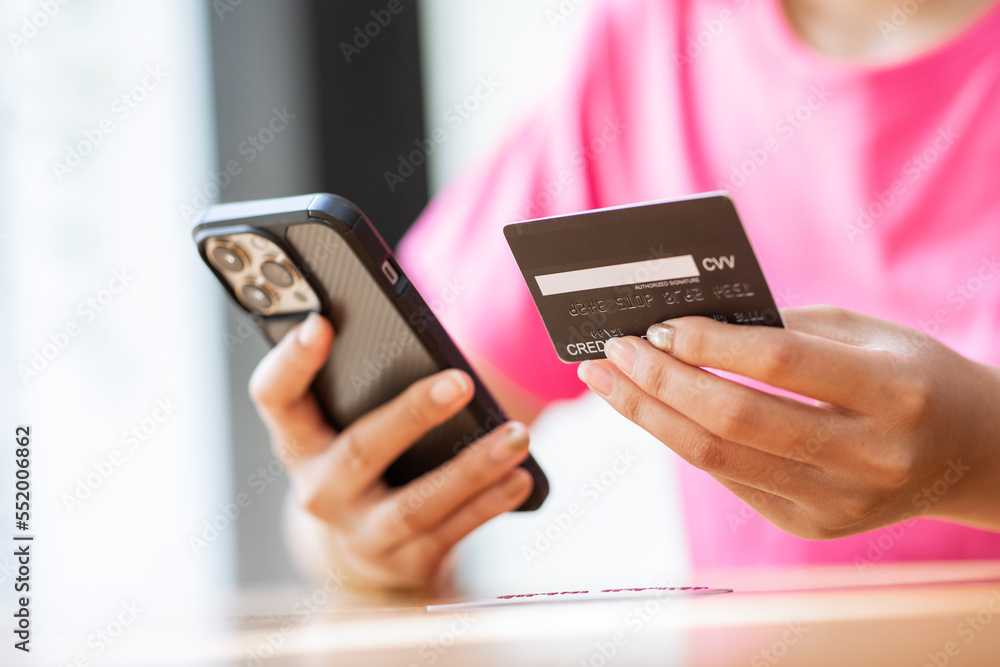 online payment Asian woman hands holding credit card and using smartphone for online shopping. online payment Asian woman hands holding credit card and using smartphone for online shopping.