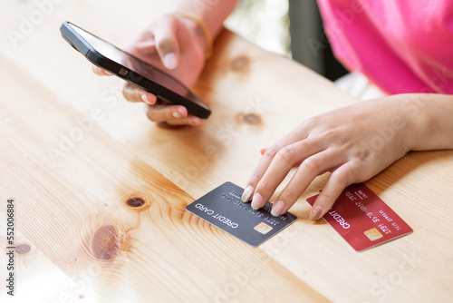 online payment Asian woman hands holding credit card and using smartphone for online shopping.