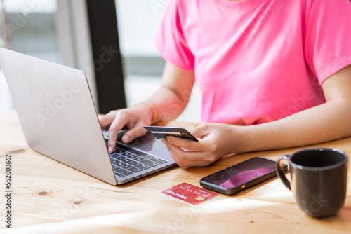 online payment Hands of young asian woman holding credit card and using smartphone for online shopping.