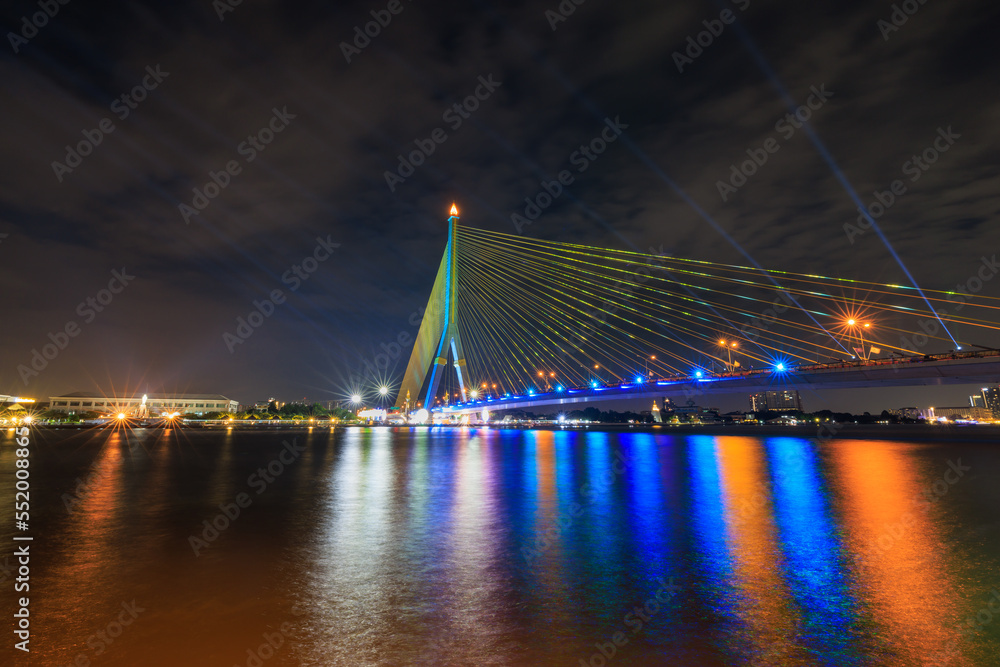 Obraz premium Rama VIII Bridge or praram 8 bridge connecting the city across the Chao Phraya River. in thailand at twilight and laser light show,
