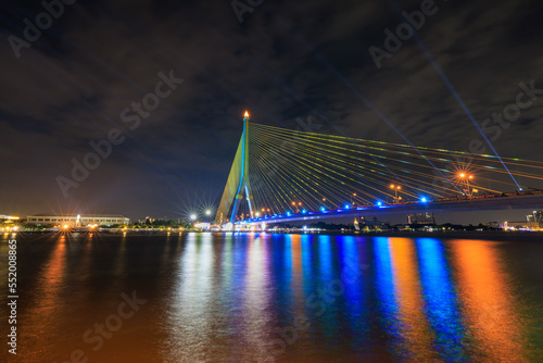 Rama VIII Bridge or praram 8 bridge connecting the city across the Chao Phraya River. in thailand at twilight and laser light show 