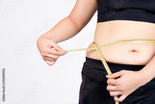 Fat woman measuring her stomach isolated on white background. concept of subcutaneous fat breakdown.