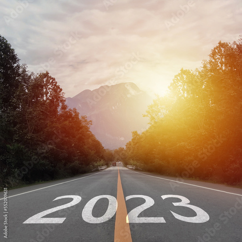 New year 2023 or straightforward concept. Text 2023 written on the road in the middle of asphalt road at sunset.Concept of planning and challenge, business strategy, opportunity ,hope, new life change photo