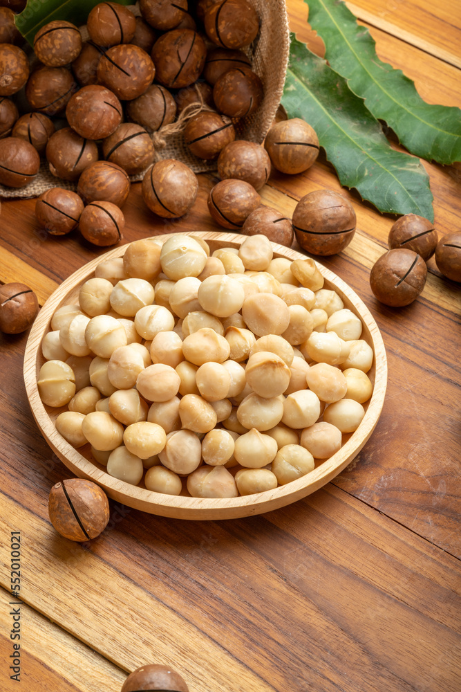 Macadamia nut in wooden plate on wooden background, Roasted Macadamia nuts on wooden background. Macadamia nut in wooden plate on wooden background, Roasted Macadamia nuts on wooden background.