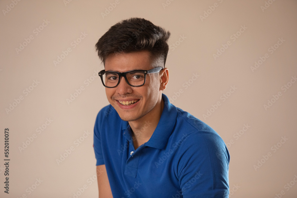 Cheerful young man in spectacles looking at camera 