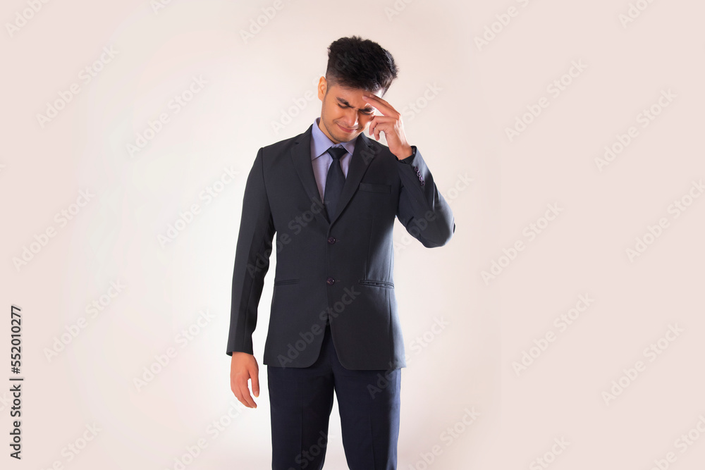 Portrait of a stressed young businessman standing with hand on head against white background Portrait of a stressed young businessman standing with hand on head against white background