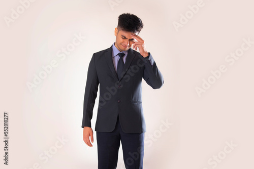 Portrait of a stressed young businessman standing with hand on head against white background