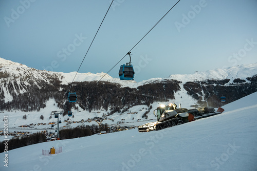 Snowcat on slope. Town of Livigno in winter. Livigno landscapes in Lombardy, Italy, located in the Italian Alps, near the Swiss border. photo