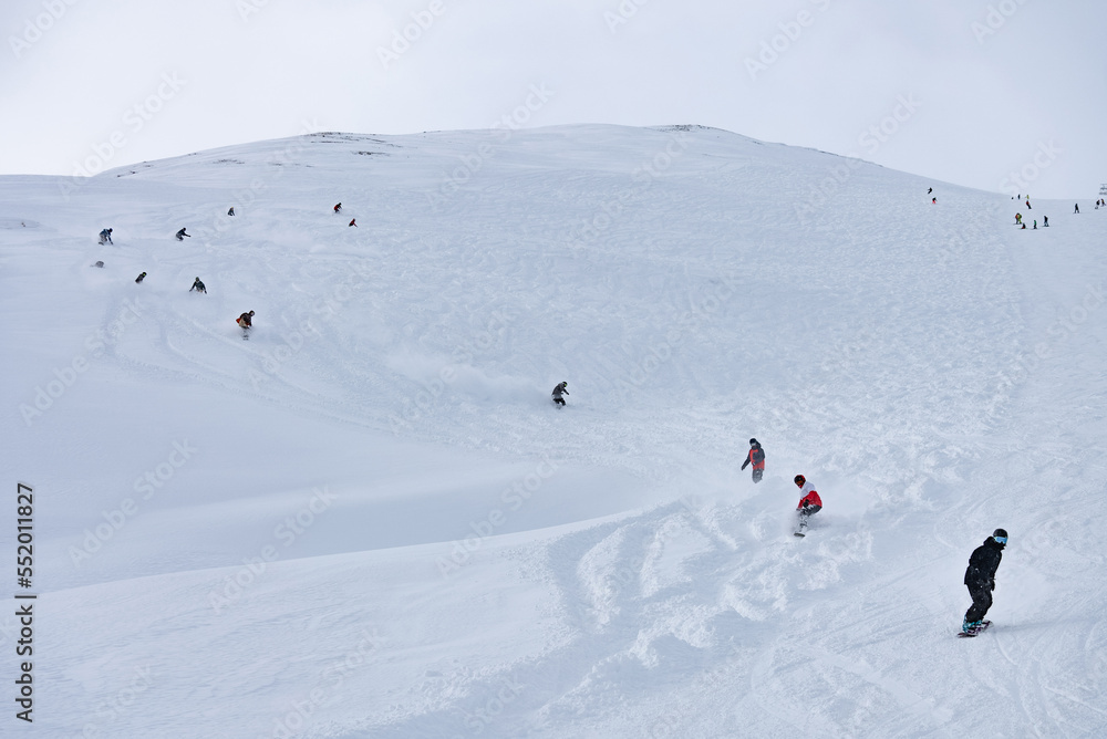 Freeride group in powder, snowboarding in alpes resort in winter. Snowboard freeride i deeep powder snow. Freeride winter in Livigno, Italy.