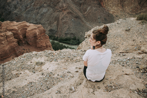 girl in the mountains near the cliff above the river  canyon  desert.