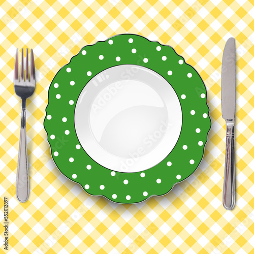 Green vector plate with figured edges and polka dot pattern placed on yellow check classic seamless tablecloth. Close up view from above.