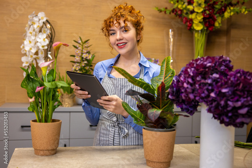Cute curly-haired girl in a flower shop looking creative