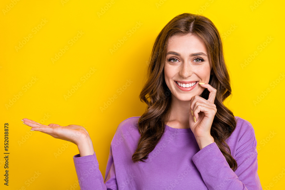 Closeup photo of young positive woman curly hair bite finger hold arm useful tips about shopping black friday isolated on yellow color background Closeup photo of young positive woman curly hair bite finger hold arm useful tips about shopping black friday isolated on yellow color background