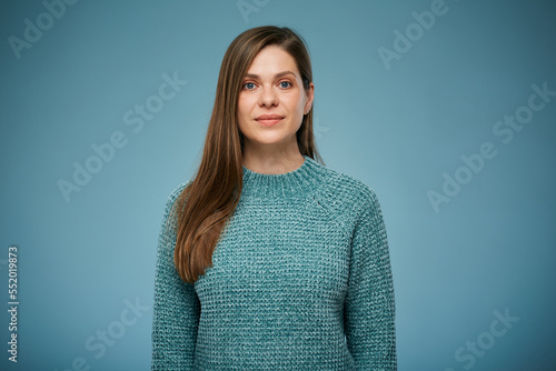 Young smiling woman in casual knitted sweater. Advertising female studio portrait on blue.