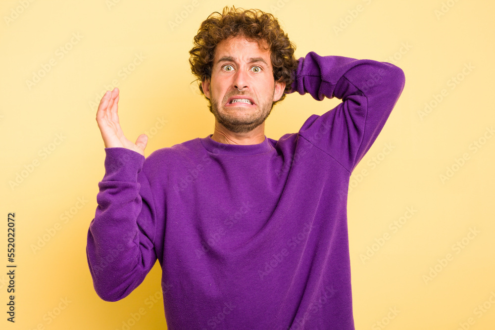 Young smart caucasian man on yellow background screaming with rage. Young smart caucasian man on yellow background screaming with rage.