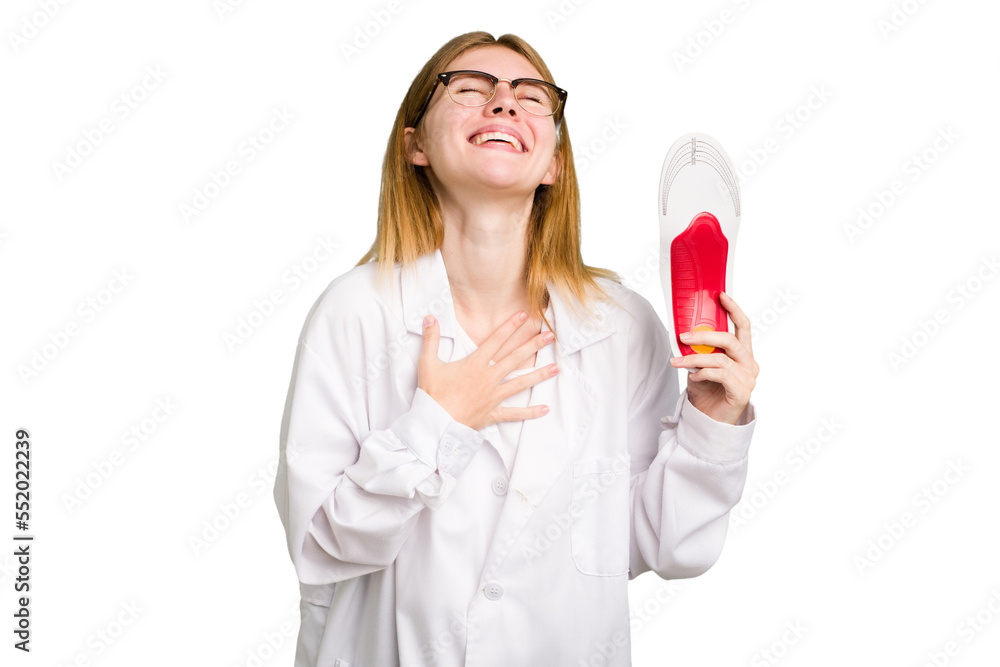 Young caucasian chiropodist woman holding an insoles for shoes isolated laughs out loudly keeping hand on chest. Young caucasian chiropodist woman holding an insoles for shoes isolated laughs out loudly keeping hand on chest.