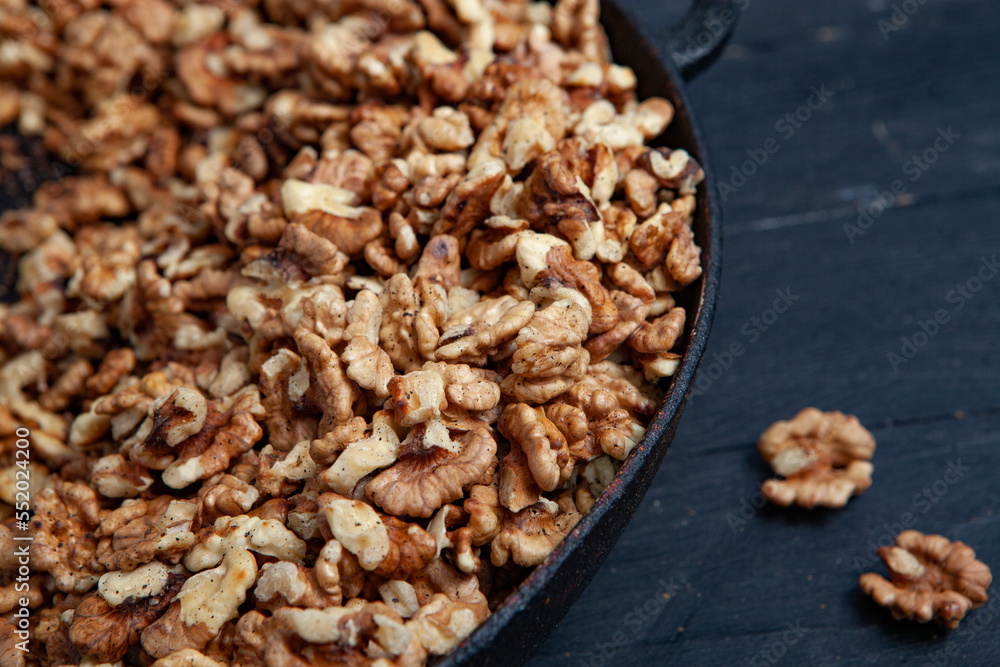 Walnut background. Peeled walnuts on a iron plate on black. walnuts a real super food full of vitamins and vegetable fats Walnut background. Peeled walnuts on a iron plate on black. walnuts a real super food full of vitamins and vegetable fats