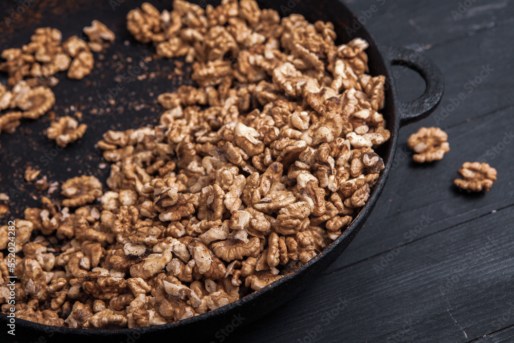 Walnut background. Peeled walnuts on a iron plate on black. walnuts a real super food full of vitamins and vegetable fats Walnut background. Peeled walnuts on a iron plate on black. walnuts a real super food full of vitamins and vegetable fats
