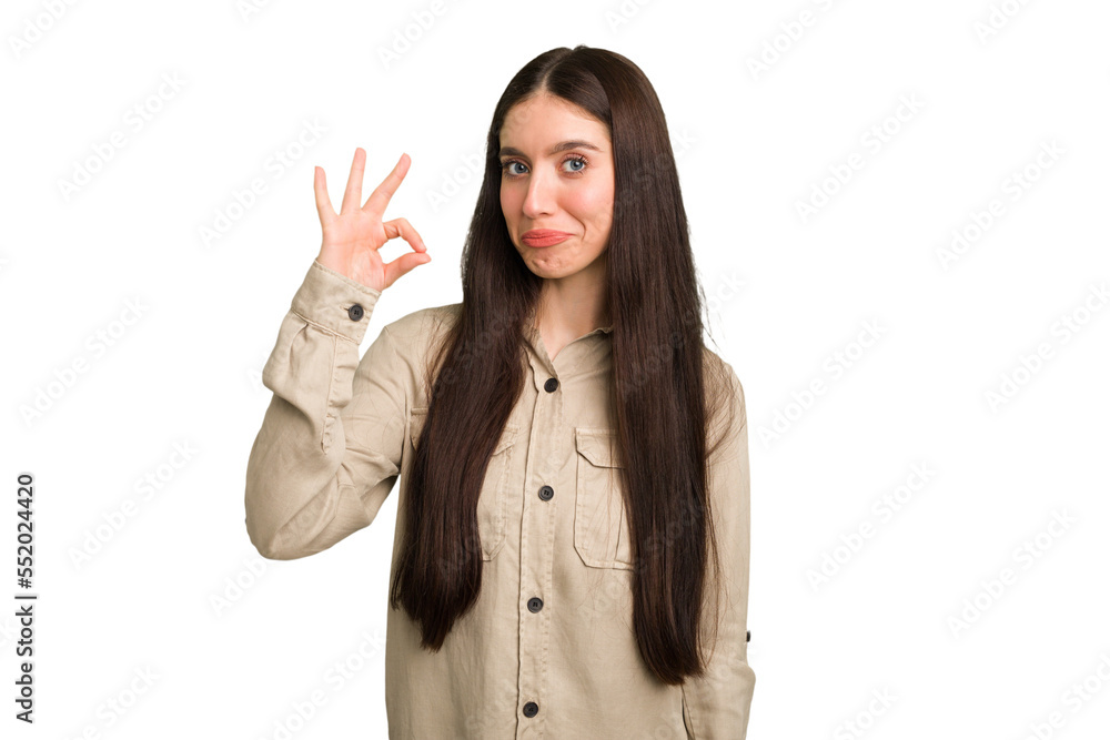 Young caucasian brunette long hair woman cutout isolated winks an eye and holds an okay gesture with hand. Young caucasian brunette long hair woman cutout isolated winks an eye and holds an okay gesture with hand.