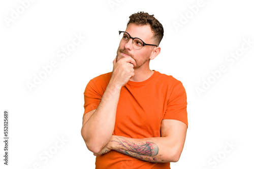 Young caucasian handsome man isolated relaxed thinking about something looking at a copy space.