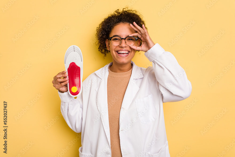 Young chiropodist brazilian woman holding a template isolated excited keeping ok gesture on eye. Young chiropodist brazilian woman holding a template isolated excited keeping ok gesture on eye.